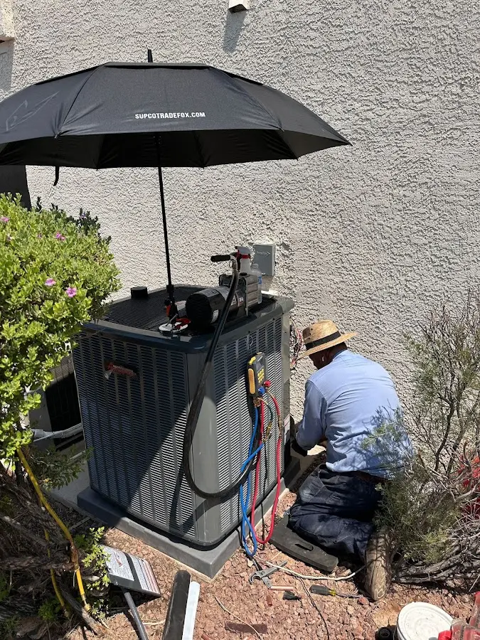 HVAC technician performing outdoor AC maintenance in Owatonna