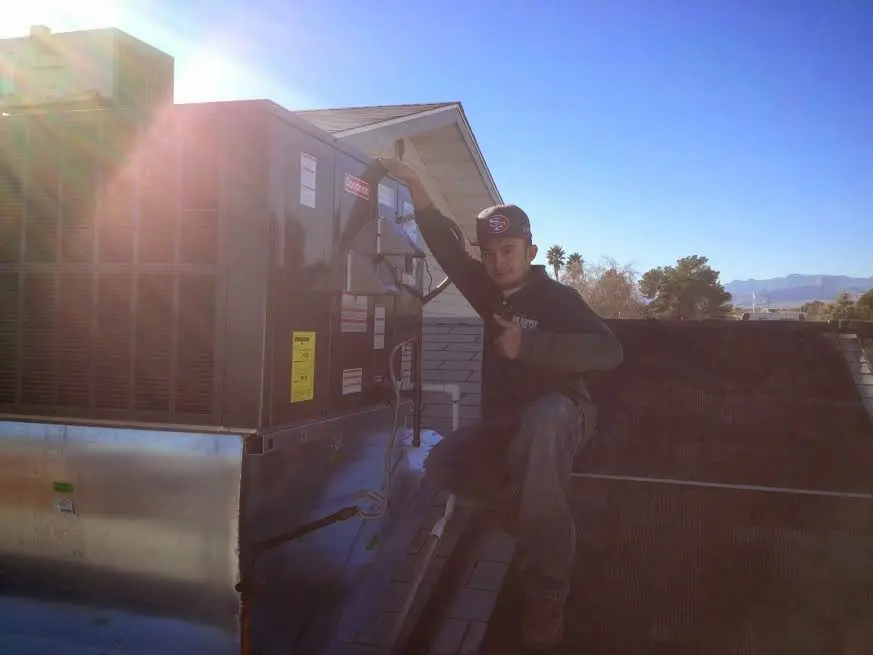 HVAC technician performing HVAC Inspection on a rooftop unit in Owatonna